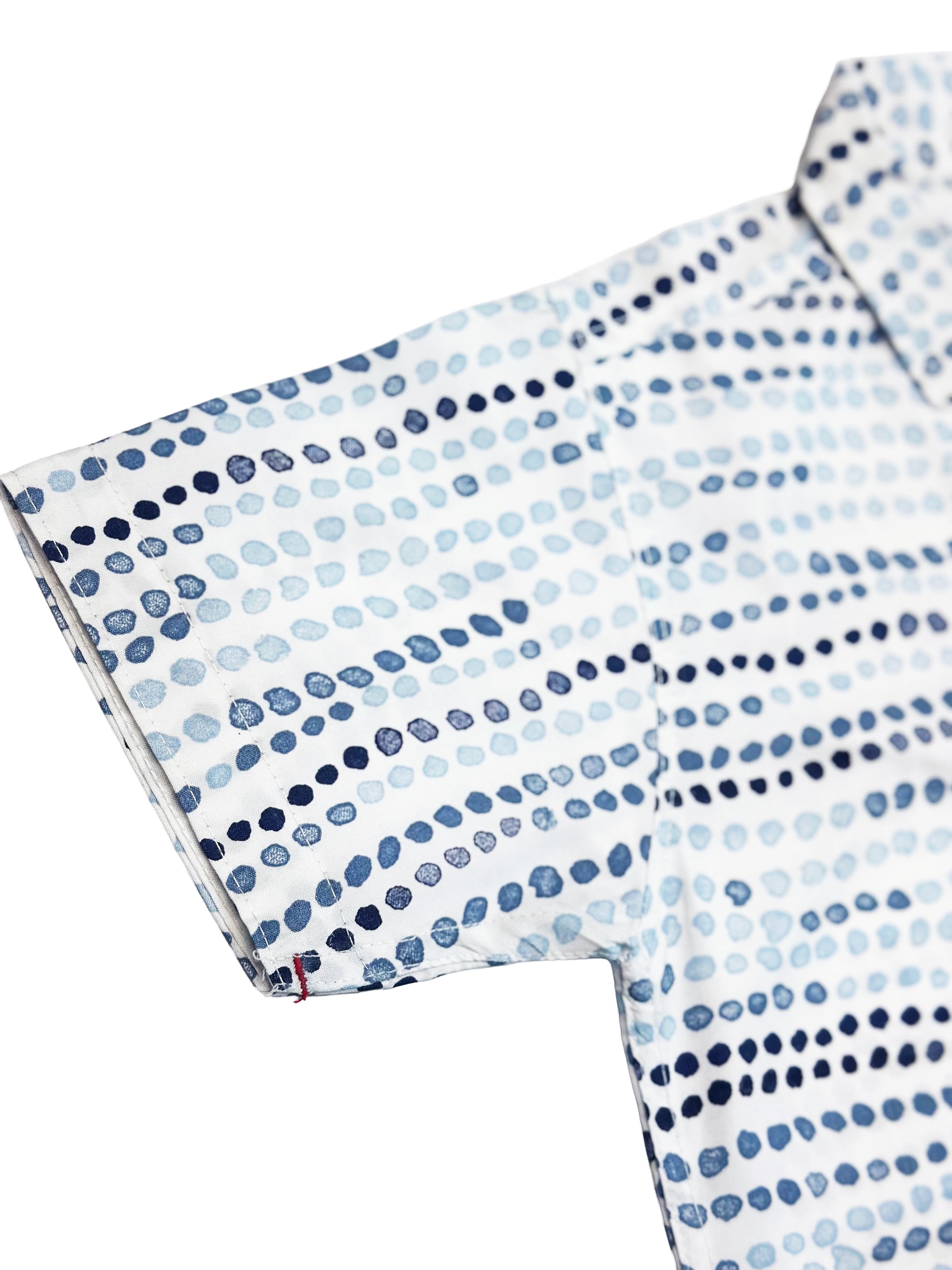 Close-up of a patterned shirt with blue and white dots on a white background